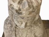 a stone statue of a person with a hat on