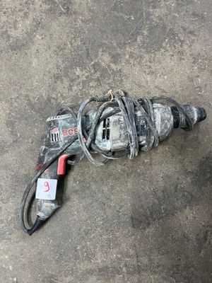 a drill that is laying on the ground next to a cord