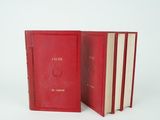 three red books sitting next to each other on a white surface