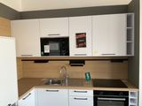 a small kitchen with white cabinets and a black stove
