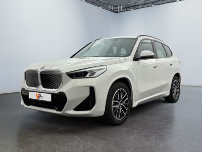 a white bmw x5 parked in a white room