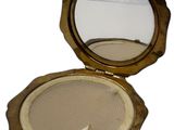 a small round mirror in the middle of a gold case