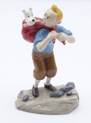 figurine représentant un garçon portant un chien sur le dos
