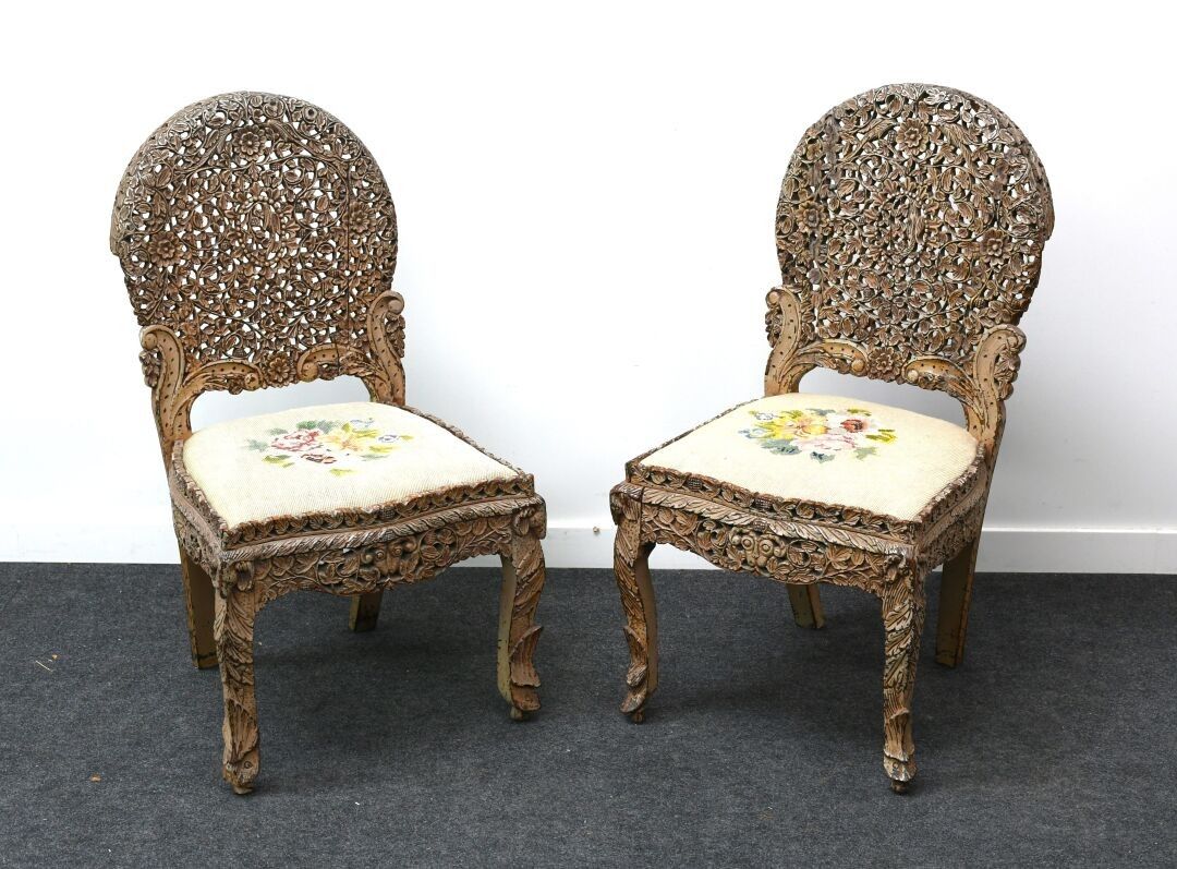 254.bis INDOCHINE Paire de chaises en bois exotique richement sculpté et ajouré de feuillages. Assise garnie d'une ta...