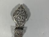 a close up of a silver bracelet with a flower design on it