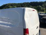 a white van parked in a parking lot with trees in the background
