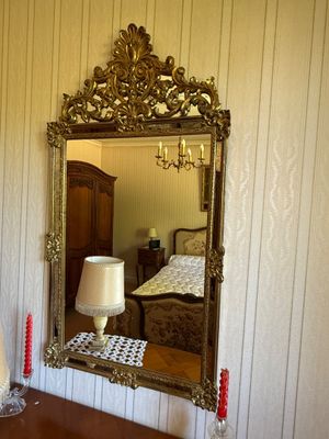 a mirror on the wall above a dresser in a room