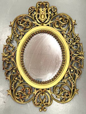 a mirror that is on the wall with a gold frame
