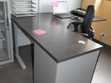 a desk with a chair and a computer on it in a room