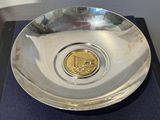 une assiette en argent contenant une pièce d'or