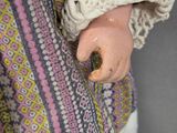 a close up of a doll ' s hand with a ring on it ' s finger
