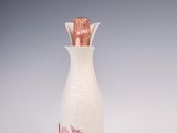 une image représentant une bouteille blanche ornée d'une fleur rose
