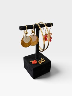 un gros plan sur un présentoir de boucles d'oreilles posé sur un socle noir