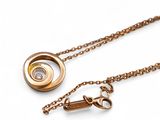 collier composé d'une chaîne en or et d'un diamant sur fond blanc