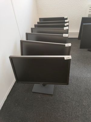 four computer monitors are lined up in a row in a room