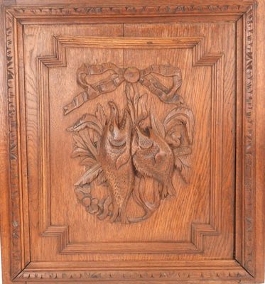an antique carved wood panel with a bird and flowers on it