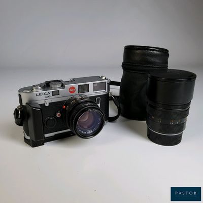 un appareil photo et un objectif posés sur une table blanche