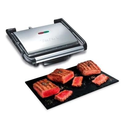 une photo d'un barbecue avec des steaks et de la viande sur une assiette noire