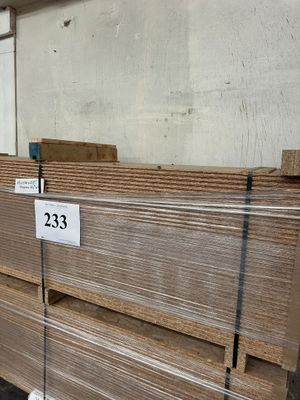 plusieurs piles de planches de bois empilées les unes sur les autres dans un entrepôt