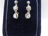 un gros plan sur une paire de boucles d'oreilles posées sur un étui en velours