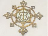 une horloge en métal sur laquelle figure un monogramme au centre