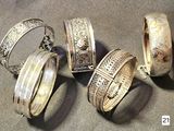 several different types of silver rings and bracelets on a table