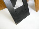 une table en bois avec un plateau noir et une chaise noire