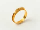 gros plan d'une bague en or sur une surface blanche