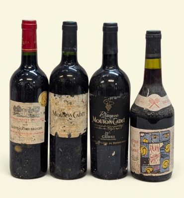 quatre bouteilles de vin sont alignées sur une surface blanche