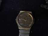 a watch that is laying on a black surface