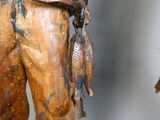 une statue représentant un homme tenant un poisson dans la main