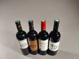 four bottles of wine are lined up on a table