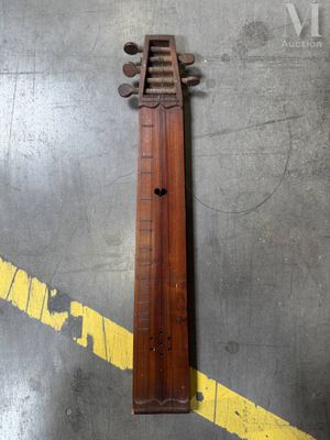 un vieil instrument en bois posé par terre, à côté d'une ligne jaune