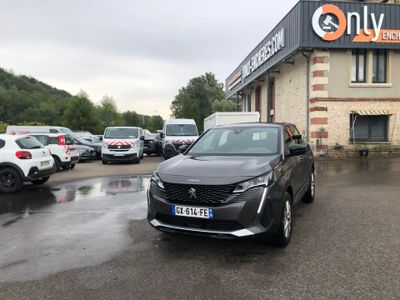 une voiture noire garée devant un bâtiment dans un parking