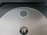 a close up of a robotic vacuum cleaner with a button on it