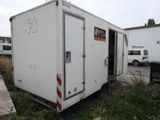 a white trailer that is parked in the grass