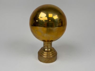 a gold ball on a gold pedestal on a white background