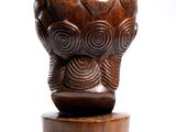 wooden sculpture of an elephant head on a wooden pedestal