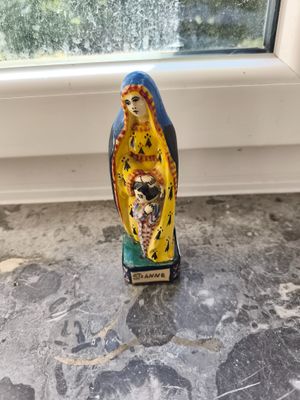 une figurine représentant une femme assise sur un rebord de fenêtre
