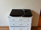 une commode blanche sur laquelle est posé un ordinateur portable