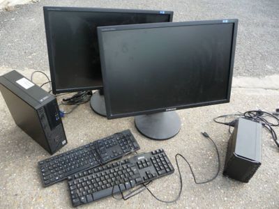 two computer monitors and a keyboard on the ground