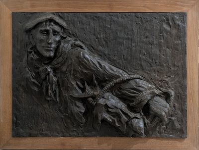 un relief noir représentant un homme assis sur un banc