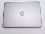 hp laptop computer sitting on top of a white table next to a keyboard