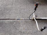 an image of a string trimmer laying on the ground