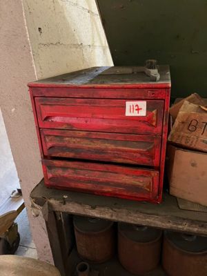 a red tool box sitting on top of a wooden table