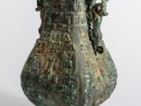 un grand vase en bronze posé sur une table
