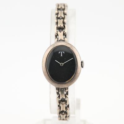 gros plan d'une montre-bracelet entourée d'une chaîne