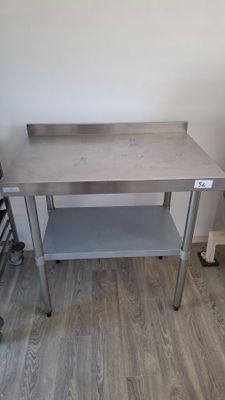 a table with a shelf on it in the corner of a room