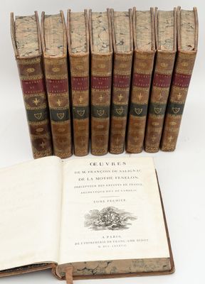 several old books sitting on top of each other next to a book