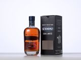 an empty bottle of whisky sitting next to a box on a table